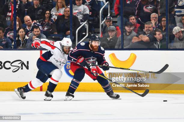 Devante Smith-Pelly of the Washington Capitals and Ian Cole of the Columbus Blue Jackets battle for position as they skate after a loose puck during...