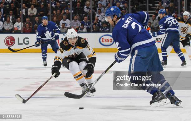 Jake DeBrusk of the Boston Bruins forechecks Ron Hainsey of the Toronto Maple Leafs in Game Four of the Eastern Conference First Round in the 2018...