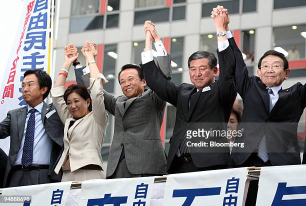 Candidates for the president of the Liberal Democratic Party raise their arms on a rooftop of a campaign van during a stumping tour in Tokyo, Japan,...