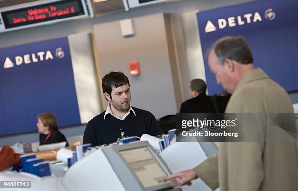 Delta Technician Gaston Alberti, center, looks over self-service kiosks in the Delta Air Lines area of Logan International Airport in Boston,...