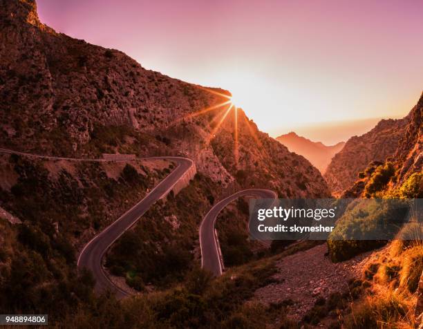 kurvenreiche straße in bergen von mallorca. - bergpass stock-fotos und bilder