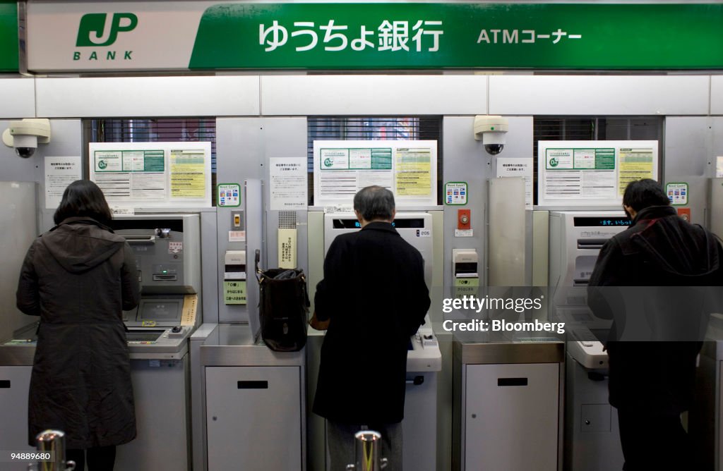 People use automatic teller machines (ATM) at a Japan Post B