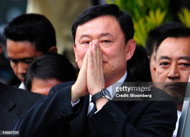 Thaksin Shinawatra, former prime minister of Thailand and owner of the Manchester City football club, greets a crowd as he arrives at the airport in...