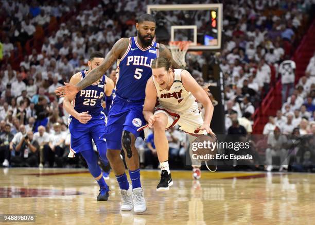 Kelly Olynyk of the Miami Heat trips while bringing the basketball upcourt while being defended by Amir Johnson of the Philadelphia 76ers/ at...