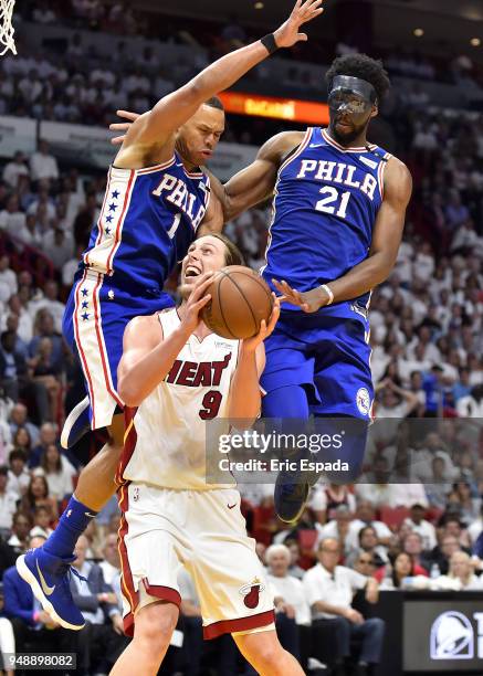 Kelly Olynyk of the Miami Heat goes up for a shot while being defended by Justin Anderson and Joel Embiid of the Philadelphia 76ers during the third...