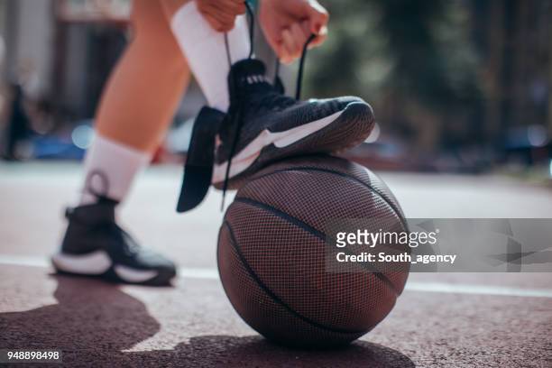 atar cordones de los zapatos antes de jugar al juego - basketball shoe fotografías e imágenes de stock