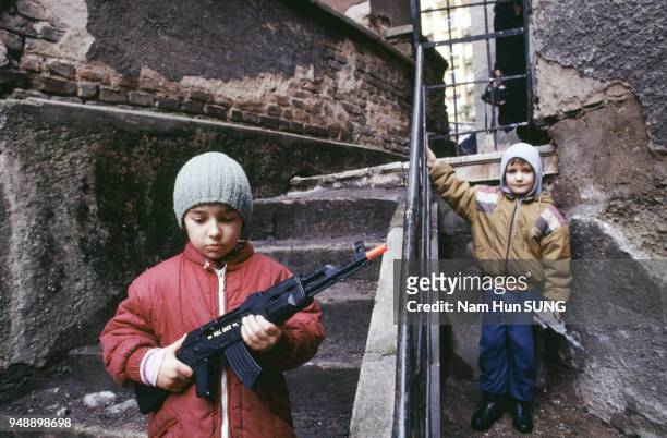 Enfant jouant à la guerre dans une rue de Sarajevo, en mars 1996, Bosnie-Herzégovine.