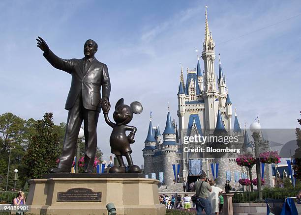 Statue of Walt Disney and Mickey Mouse stands in front of the Cinderella's castle at Walt Disney World's Magic Kingdom in Lake Buena Vista, Florida,...