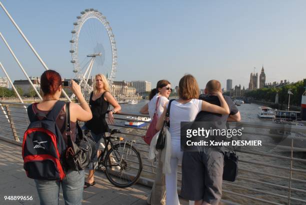 Passerelle pietonne, Hungerford Bridge. A gauche, la British Airways London Eye, grande roue panoramique en forme de roue de velo construite pour les...