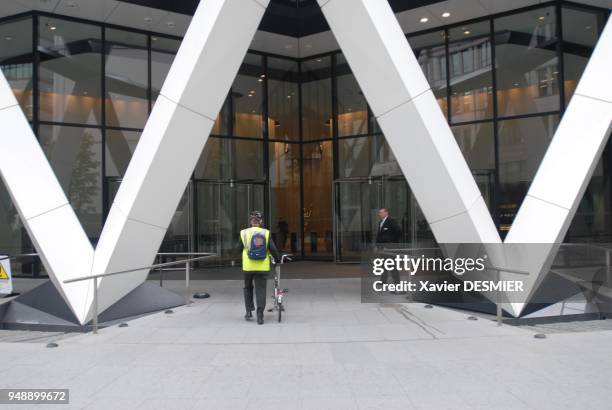 Quartier de la City. Cycliste se rendant sur son lieu de travail, immeuble icone con?u par Norman Foster, siege de la Swiss Life, The Gherkin. The...