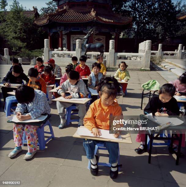 Cours de dessin pour enfant dan la cité Interdite à Pékin, en 2002, Chine.