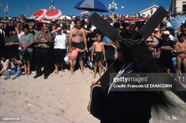 Femme Christ sur la plage portant la Croix lors d'une fête à Saint Bartolomeu do Mar au Portugal en 1996.