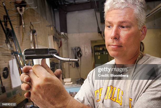 David Mills demonstrates the perfect balance of a T.P. Mills hand-milled golf putter at his workshop in Tuscaloosa, Alabama, U.S., on Thursday, May...