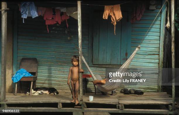Enfant nu sur la terrasse d'une maison à Puerto Cabezas, en septembre 1984, Nicaragua.