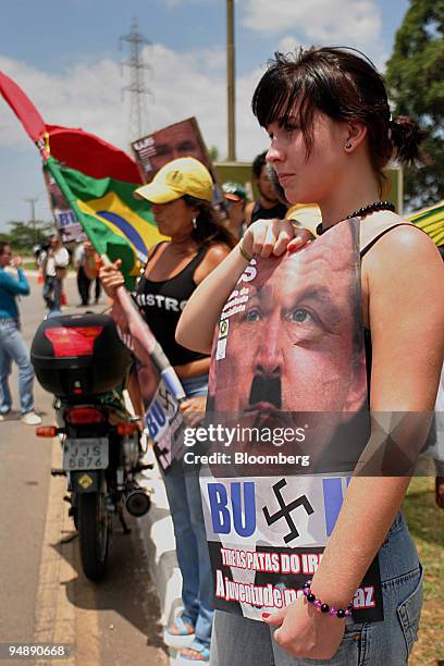 Brazilian protestor holds a sign likening visiting U.S. President George W. Bush to a Adolf Hitler November 6, 2005 at a roadside in Brasilia,...