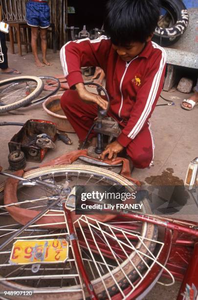 Enfant travaillant dans un garage à vélo, travail des enfants, Saigon, Vietnam 1987.