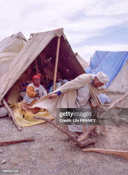 Paysan inspectant un araire avant l'achat, sur le marché du moussem d'Imilchil, dans le Haut Atlas au Maroc, en 1983.