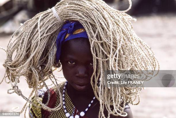 Petite fille transportant de la ficelle à Mopti, en décembre 1987, Mali.