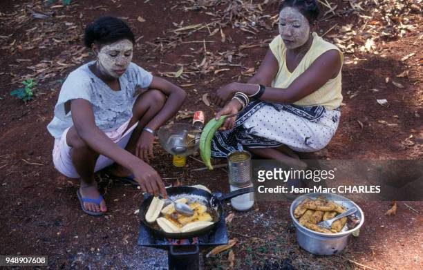 Femmes portant des masques de beauté à partir de bois de santal sur le visage, à Mtsamboro, en octobre 1990, Mayotte.