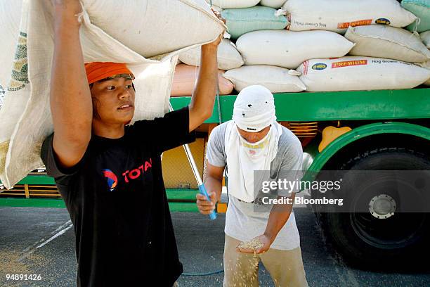 Rice certifier stabs at a sack of rice to get a core sample to check for quality at a rice mill in Nueva Ecija, the Philippines, on Friday, May 23,...