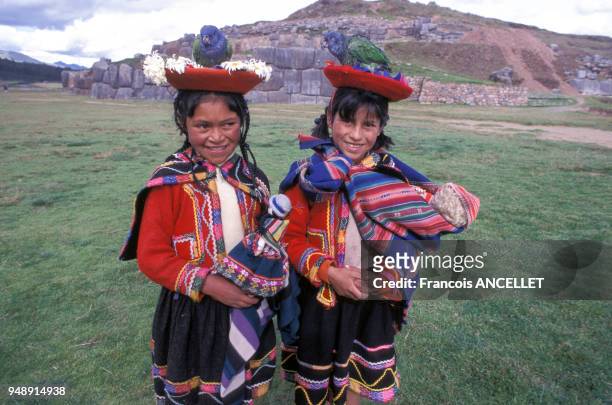 Petites filles indiennes en costume traditionnel, devant forteresse de Sacsayhuaman, à Cuzco, en 1999, Pérou.