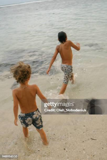 niños jugando en el mar - melasti fotografías e imágenes de stock