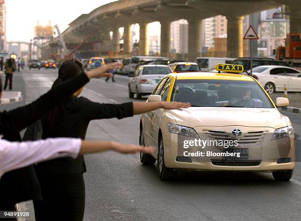 People try to hail a taxi in Dubai, United Arab Emirates, on Thursday, May 22, 2008. About 6,000 taxis and 500 buses serve more than six million...