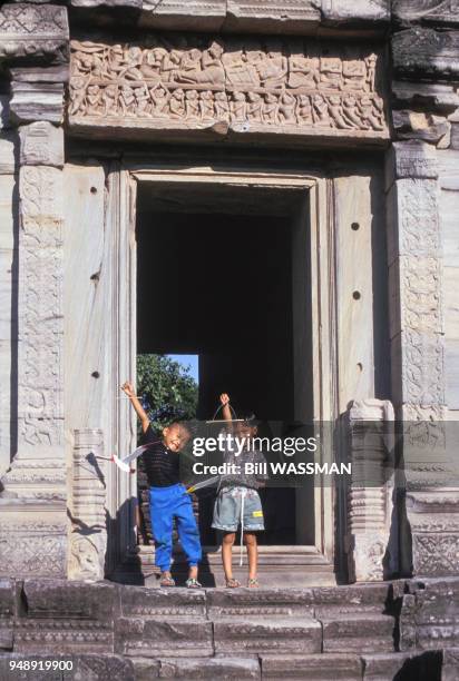 Enfants posant devant une porte du temple khmer Prasat Hin Phimai en Thaïlande, en décembre 1993.