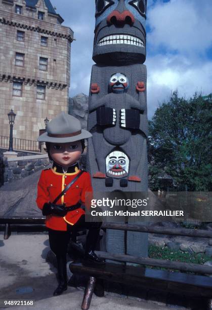 Employé en costume de la police montée canadienne au pied d'un totem, dans le parc à thème EPCOT à Orlando, en décembre 1982, en Floride, Etats-Unis.