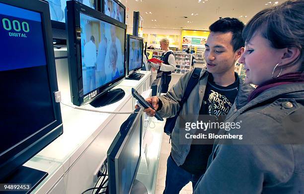 Steffi Neumann and Binh Vuduc shop for flat screen televisions at the Galeria Kaufhof department store in Berlin, Germany, on Tuesday, Feb. 26, 2008....