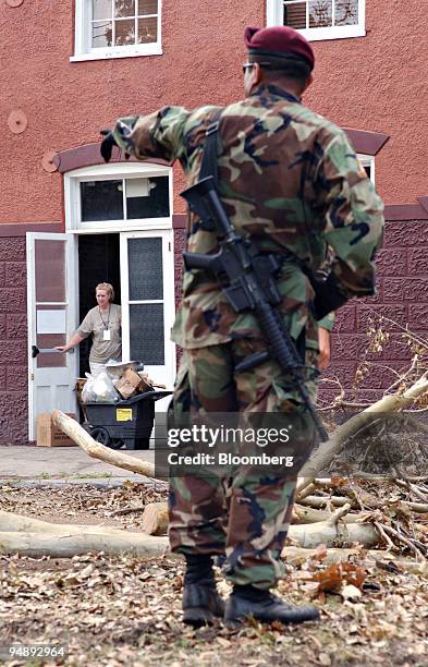 Resident Karen Lott stands in a doorway as a a member of the 307 Engineers attached to the 82 Airborne out of Fort Bragg, Texas, directs clean-up in...