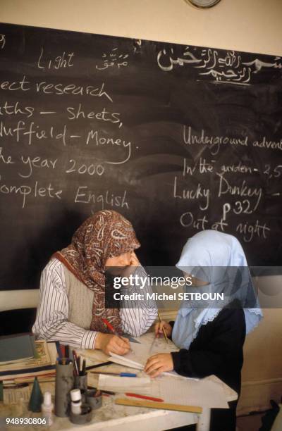 Intsitutrice musulmane avec une élève en classe, dans une école publique de Batley, en 1989, Royaume-Uni.