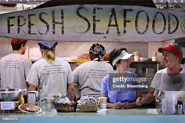 Marsha Williams, second from the left, and Dale Maher, right, work the counter at the Yacht Basin Provision Co., a seafood restaurant and bar in...