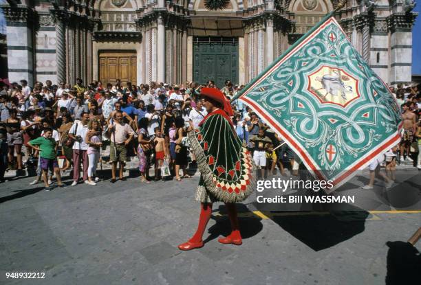Porte-drapeau passant devant la cathédrale de Sienne pendant le parade précédant la course du Palio, en Italie, en 1990.