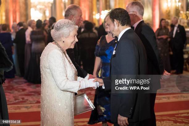 Queen Elizabeth II greets Sultan of Brunei Hassanal Bolkiah in the Blue Drawing Room in the Blue Drawing Room at The Queen's Dinner during the...