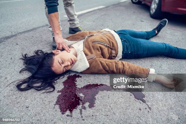 woman lying in blood on the road - dead body blood stock pictures, royalty-free photos & images