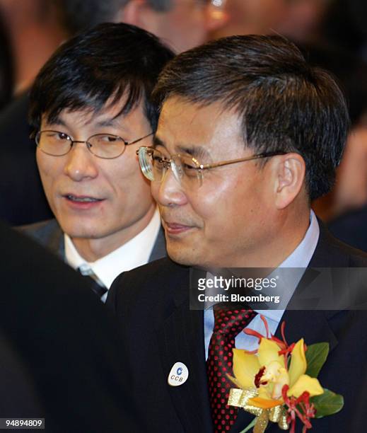 China International Capital Corp. General Manager Levin Zhu, left, walks with China Construction Bank Corp. Chairman Guo Shuqing, right, at the...
