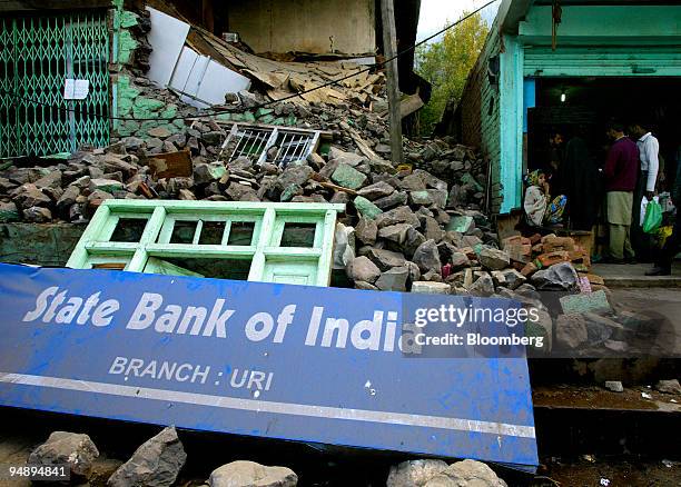 Sign for the State Bank of India lays amongst debris outside a collapsed branch in Uri near the Line of Control, in the Indian Administered Kashmir,...