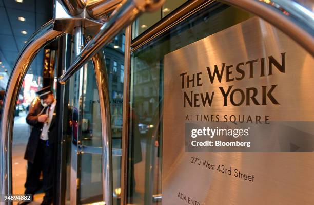 Hotel doorman speaks on the phone as he helps the guests at a Westin Hotel on 43rd Street in midtown Manhattan on Wednesday, October 26 in New York...