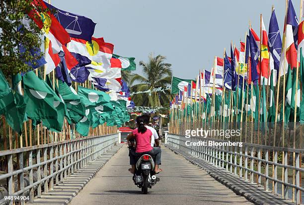 Motorist drives past election flags for Pan-Malaysian Islamic Party , Barisan Nasional and the United Malays National Organization at a fishing...