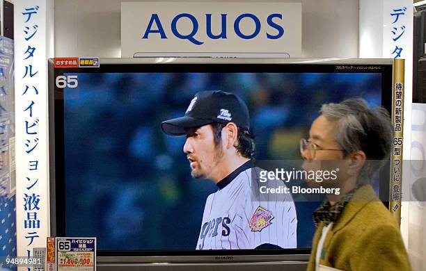 Woman walks past a 65 inch Sharp Corp. LCD TV in a Tokyo electronics store Wednesday, October 26, 2005.