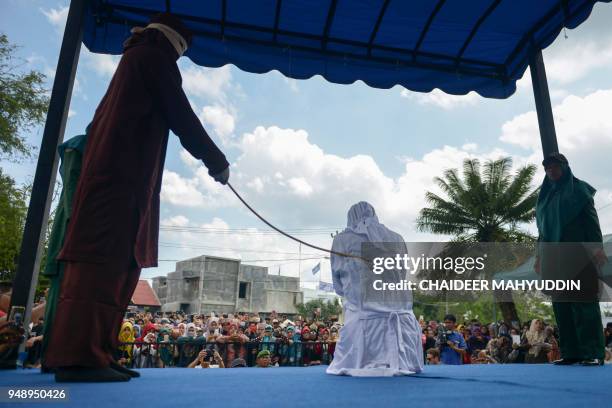 Woman is publicly flogged in front of a mosque in the provincial capital Banda Aceh on April 20, 2018. - A group of amorous couples and prostitutes...