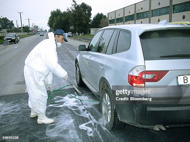 Romanian ministry of transportation workers spray disinfectant on the tires of cars and trucks in an effort to stem the spread of bird flu in the...