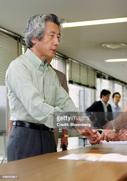 Japanese Prime Minister Junichiro Koizumi hands in his absentee ballot to officials at the Chiyoda Ward Office in Tokyo Tuesday, September 6, 2005....