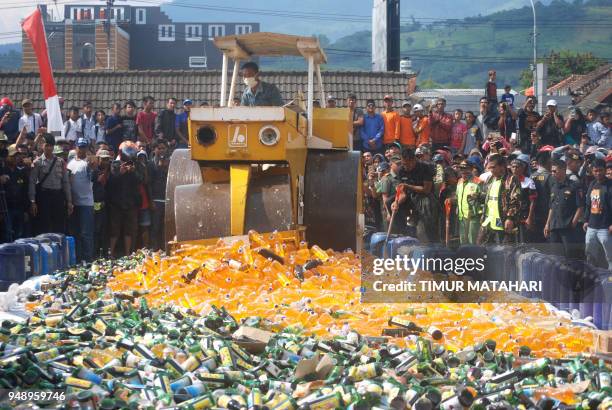 This picture taken on April 19, 2018 shows Indonesian authorities destroying recently seized bootleg liquor in Bandung, West Java province. - Police...