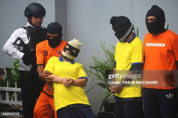 This picture taken on April 19, 2018 shows Indonesians police parading suspects arrested in recent raids on bootleg liquor haunts in Bandung, West...