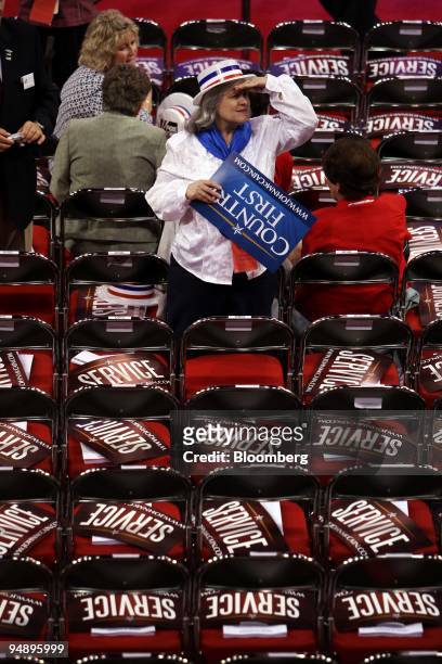 Delegate looks out over the floor, where signs reading "Service" and "Country First" have been placed on seats, on day two of the Republican National...