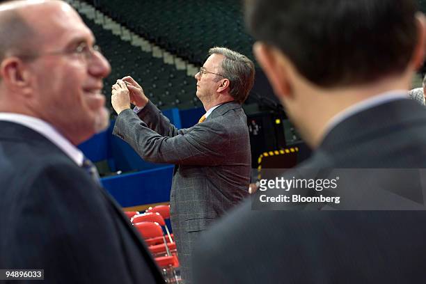 Eric Schmidt, chairman and chief executive officer of Google Inc., center, takes a photo of the stage on day two of the Republican National...