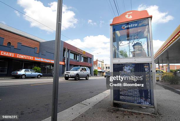 Customer uses a Telstra Corp. Public telephone booth in Melbourne, Australia, on Thursday, Feb. 21, 2008. Telstra Corp., Australia's largest...