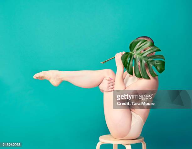 woman holding leaf in yoga pose